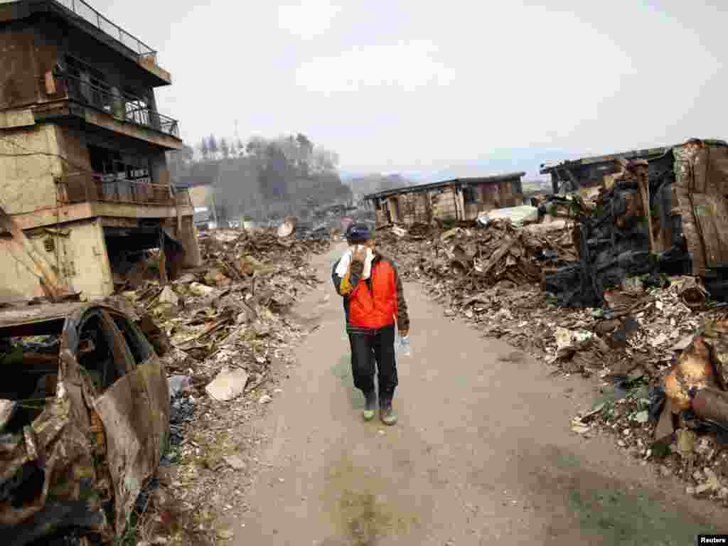 A man covers his face as he walks through a former residential area of Otsuchi on March 14