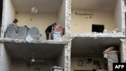 Цивільні фотографують пошкоджений будинок у місті Алепо після повідомлень про авіаудари урядових військ, Сирія, 7 грудня 2015 