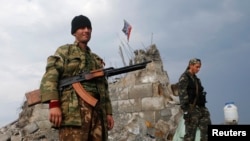 Pro-Russian separatists patrol beside a destroyed war memorial near the city of Donetsk on August 28. Despite continued fierce fighting in eastern Ukraine, most interested parties seem to be going out of their way to avoid calling the conflict a "war." 