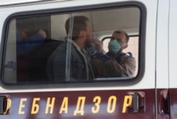 A medic takes a swab from a man inside a mobile laboratory for COVID-19 testing near St. Petersburg's Pulkovo airport in Russia on March 23.