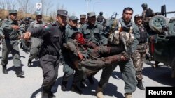 Полицейлер жарылыстан зардап шеккен адамды көтеріп барады. Кабул, 25 наурыз 2014 жыл.