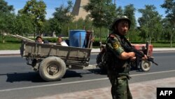 A Chinese paramilitary policeman mans a checkpoint on the road to the riot-affected Uyghur town of Lukqun in Xinjiang Province on June 28.