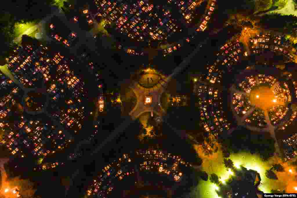 The orange and green glow of candles and lights from the cemetery in Zalaegerszeg