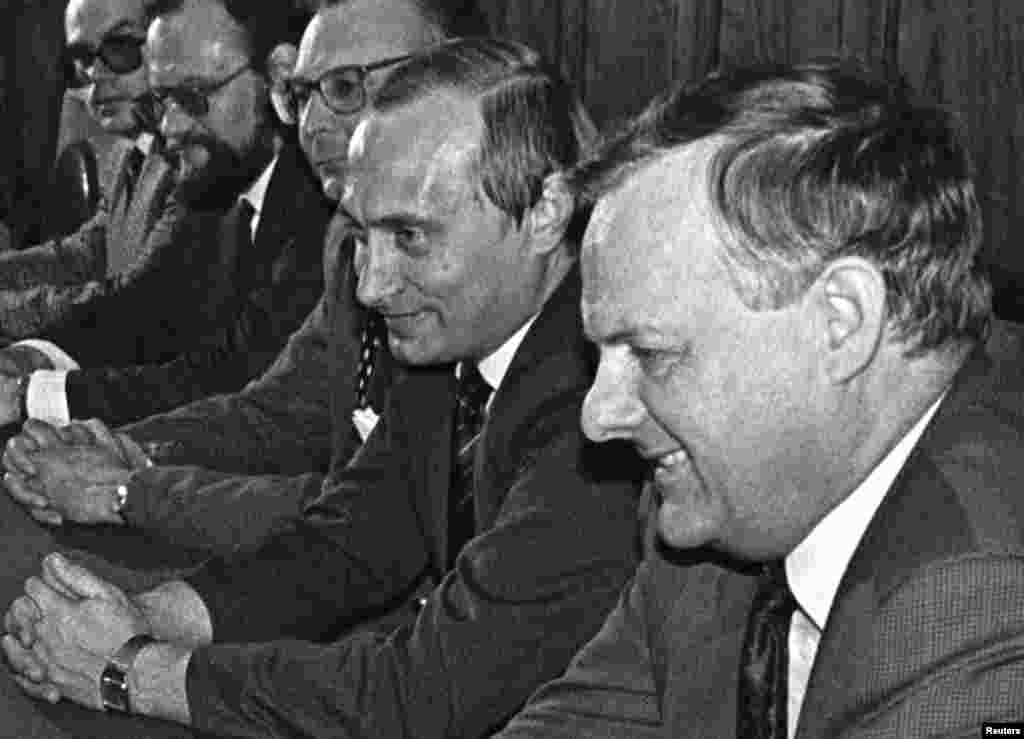 Anatolij Szobcsak (jobbra), a szovjet korszak egyik vezető reformere, Szentpétervár korábbi polgármestere Vlagyimir Putyin (balra) mellett 1993-ban. Későbbi, orosz politikai karrierje Szobcsak mellett indult, amikor az idősebb politikus felkérte Putyin, hogy vegyen részt a kampányában. Anatolij Szobcsak 2000-ben szívinfarktusban halt meg két testőrével együtt. Halálát továbbra is viták övezik, egyesek azt feltételezik, hogy meggyilkolták, és hogy ebben maga Putyin is benne volt
