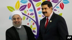 Iran's President Hassan Rouhani, left, and Venezuela's President Nicolas Maduro, shake hands during the inauguration of the 17th Non-Aligned Movement Summit in Porlamar, Venezuela, Saturday, Sept. 17, 2016. (AP Photo/Ariana Cubillos)