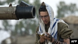 Израильский солдат читает утренние молитвы