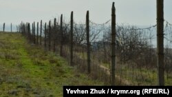 Территория огорожена столбами с колючей проволокой