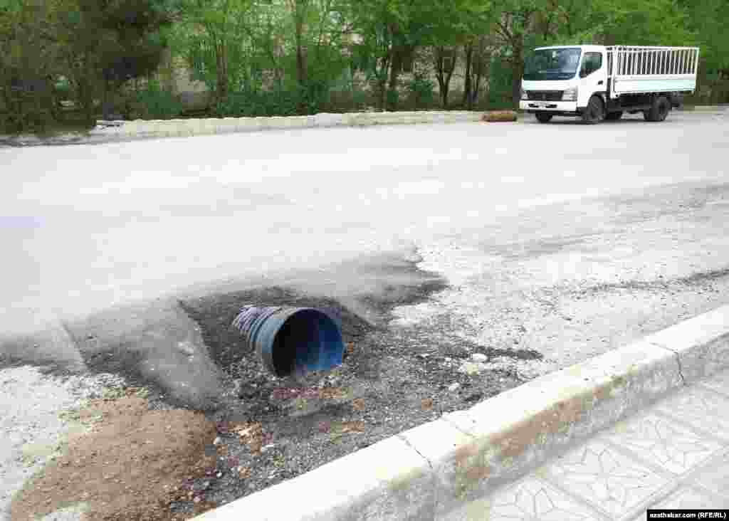 Turkmenistan. 10. street road fails. blue cutted pipe and white car