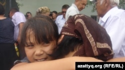 Дочь погибшего полицейского Руслана Жолдыбаева, Аида успокаивает маму. Поселок Шубаркудык, Актюбинская область, 22 июня 2012 года.