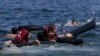 FILE: Refugees float as they hold a tube after a dinghy carrying Syrian and Afghan refugees deflated some 100m away before reaching the Greek Island of Lesbos in September 2015.