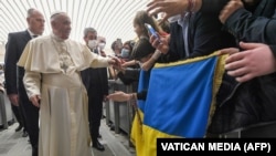 Pope Francis meets with attendees holding the national flag of Ukraine during his weekly general audience in the Vatican on March 16.