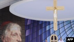 Pope Benedict XVI (center) presides over a Mass to beatify Cardinal John Henry Newman (left) in Birmingham today.