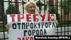 Жительница Алматы Ольга Панина на одиночном пикете у ограды городской прокуратуры, 28 августа 2015 года.