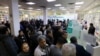 Iranians wait to get medication and masks at the state-run "13 Aban" pharmacy in Tehran, February 19, 2020