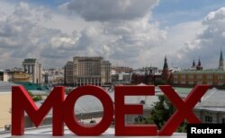 Буквы MOEX на здании Московской биржи, на заднем плане Кремль и отель Four Seasons. Москва, 26 мая 2017 года