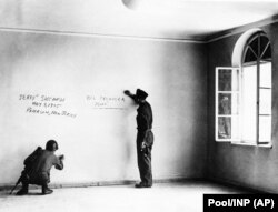در این تصویر بازمانده از ۱۴ ژوئن ۱۹۴۵، دو سرباز آمریکایی در حال ثبت نام خود بر دیوار داخلی خانه محل تولد هیتلر هستند