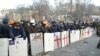 Protesters wearing helmets form a defensive line.