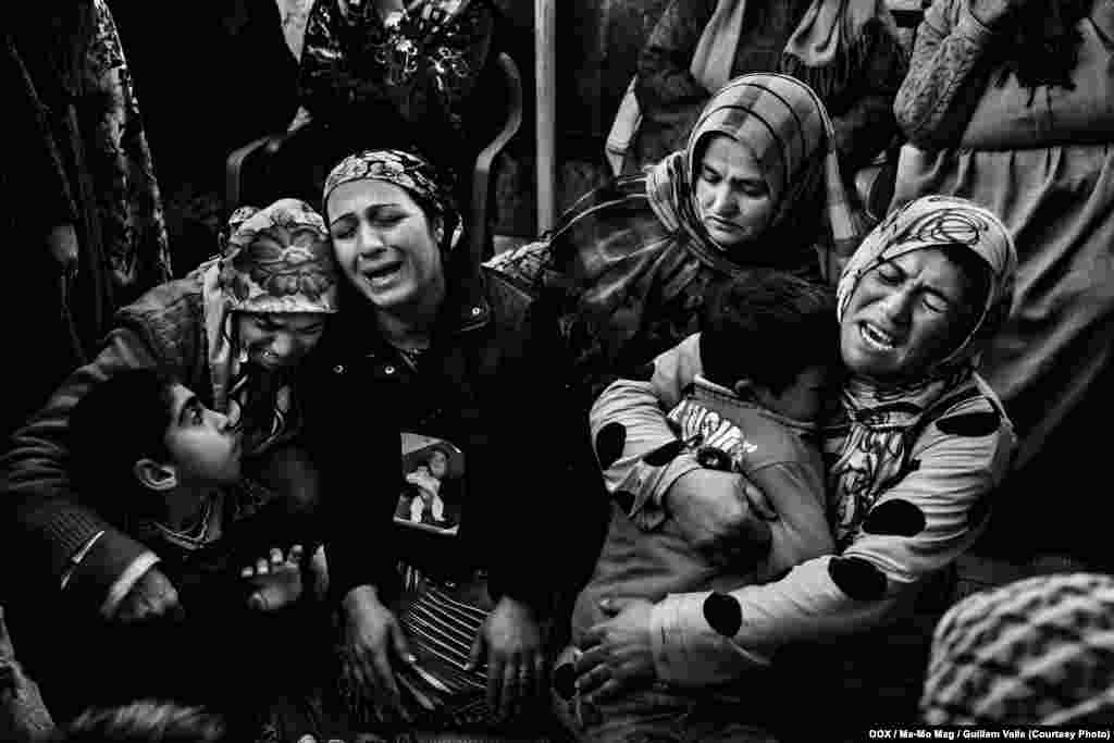 Relatives mourn at the home of a Kurdish woman who was killed after visiting the grave of her son in Serekaniye, Syria, on December 31, 2012.