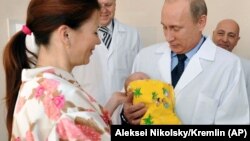 Vladimir Putin holds a newborn baby during a visit to a maternity hospital in Kaliningrad. The Russian president has made boosting the country's birthrate one of his core policies, but results have been mixed. 