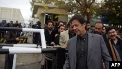 akistani cricketer-turned-opposition leader and head of Pakistan Tehreek-i-Insaf, Imran Khan, right, leaves the Supreme Court after attending a hearing on the Panama Papers in Islamabad on January 6.