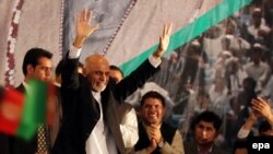 Afghan President-elect Ashraf Ghani waves to supporters during a ceremony in Kabul on September 22.