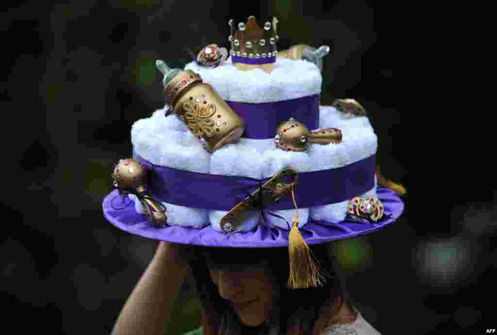 A woman wears a royal baby-themed hat during the Royal Ascot horse race in Berkshire.