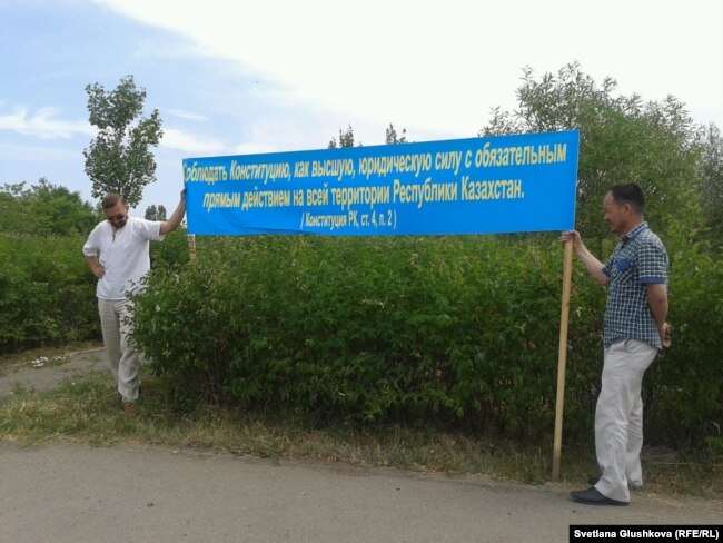 Активисты в Астане держат баннер, призывающий соблюдать Конституцию страны. 28 марта 2014 года.