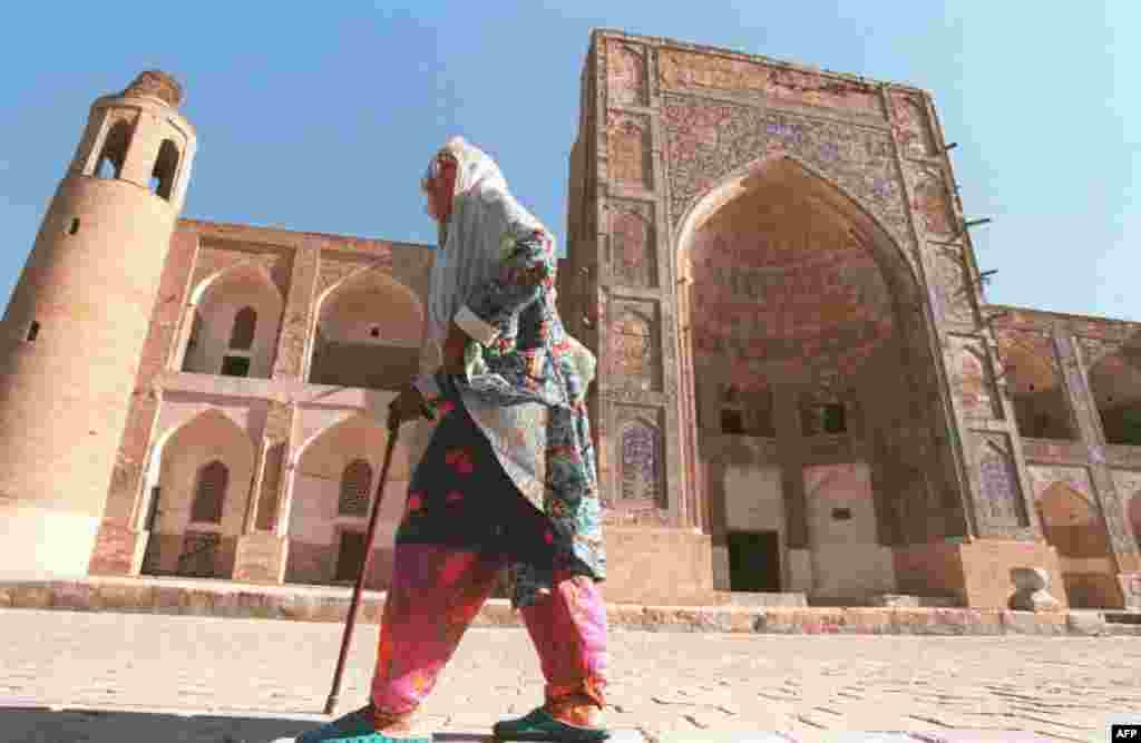 A woman walks past the Uluh-Beg Madrasah, a Koranic school in Bukhara.