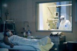 Ljekar kroz staklo promatra stanje pacijenta oboljelog od Covid-19 u moskovskoj bolnici