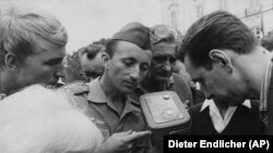 Czechs, among them a soldier holding a radio, stand near the Castle in Prague, Czechoslovakia, August 27, 1968 listening to today's speeches and announcements after Czech leaders returned from negotiations at the Kremlin with Soviet leaders. The Soviet Union and four Warsaw Pact allies invaded the country August 20, 1968. (AP Photo/Dieter Endlicher)