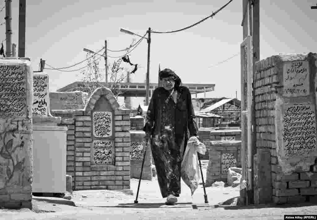 Человек, потерявший ногу во время иракской войны, идет вдоль кладбища Вади-ус-Салам, которое считается крупнейшим кладбищем в мире. Там, как полагают, похоронено более пяти миллионов человек.
