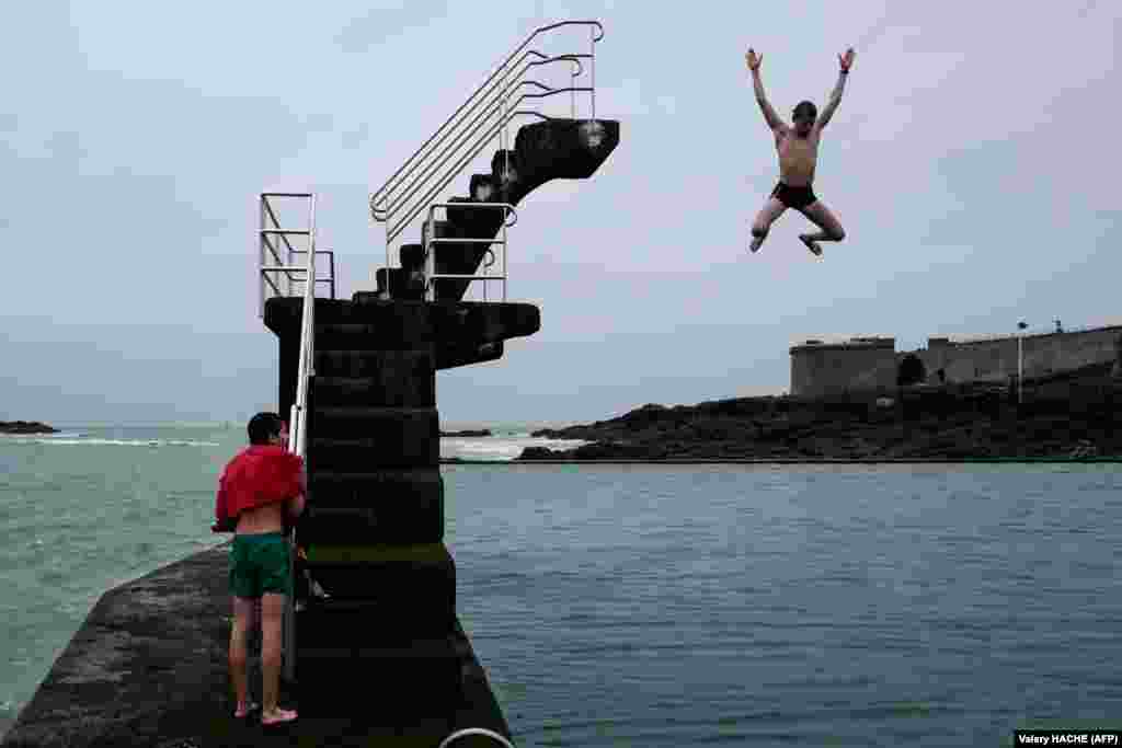 Youngsters jump into the sea from a diving platform in Saint-Malo, northwestern France. (AFP/Valery Hache)