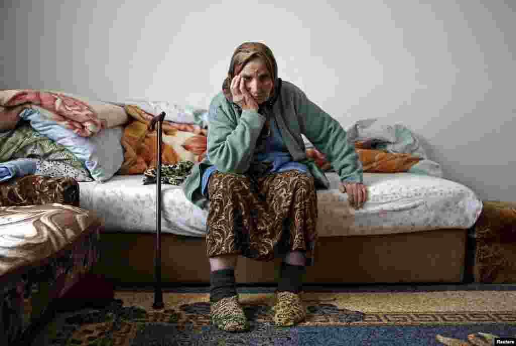 Emina Osmanovic is seen in her home in a refugee camp near Banovici, Bosnia-Herzegovina. Emina is among several thousand women still searching for the remains of their closest relatives 20 years after the Srebrenica massacre of 8,000 Muslim men and boys. She is searching for her son. She lost 15 close family members. "I don't know what is worse: To find his bones and know for sure that he was killed, that he is gone, or this waiting, suspense." (Reuters/Dado Ruvic)