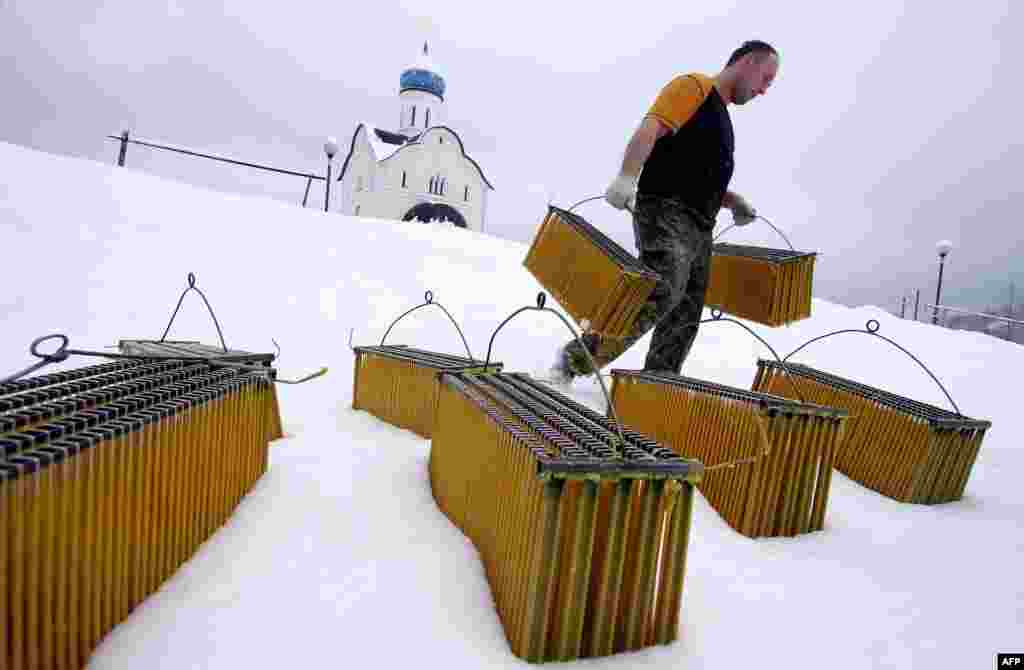 A man carries candles after cooling them in the snow in the Belarusian village of Lysaya Gora. (AFP/Sergei Gapon)