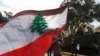 A protester waves a Lebanese flag during a protest against corruption and the failure of long-serving politicians to form a government, in Beirut, Lebanon, Thursday, Nov. 22, 2018. Lebanon is marking 75 years of independence with a military parade Thursda