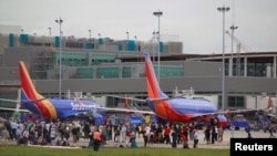 People on the airport ramp area near terminals 1 and 2 are seen following a shooting incident