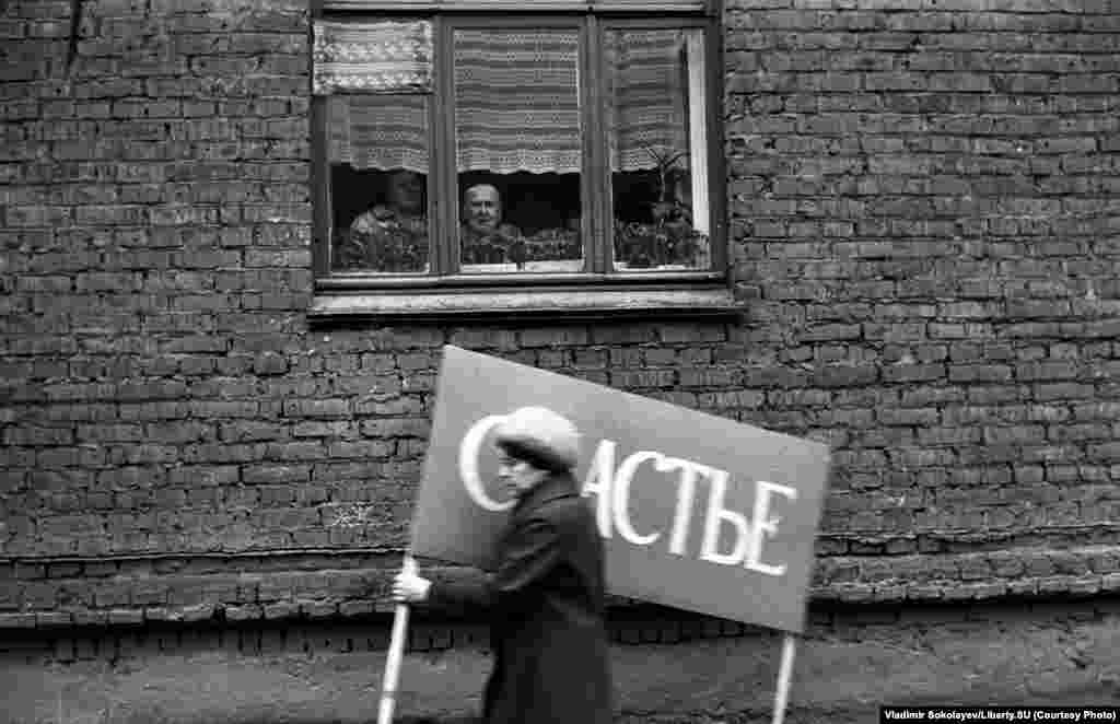 Спешащая на демонстрацию носительница &quot;СЧАСТЬЯ&quot;. Улица Обнорского. Новокузнецк. 1 мая 1983 года.