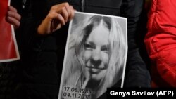 Архивска фотографија- луѓе држат портрет на украинска активистка во борбата против корупцијата Катерина Ханџјук во знак на нејзино сеќавање