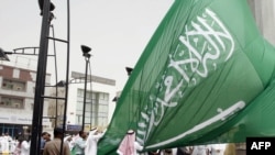 Saudi men unfurl a giant Saudi national flag