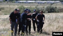 Група міжнародних експертів, включно з поліцейськими з Нідерландів, працює на місці падіння літака рейсу MH17, 1 серпня 2014 року