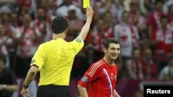 Немецкий рефери показывает российскому футболисту жёлтую карточку во время матча чемпионата Европы - 2012. Варшава, 12 июня 2012 года.