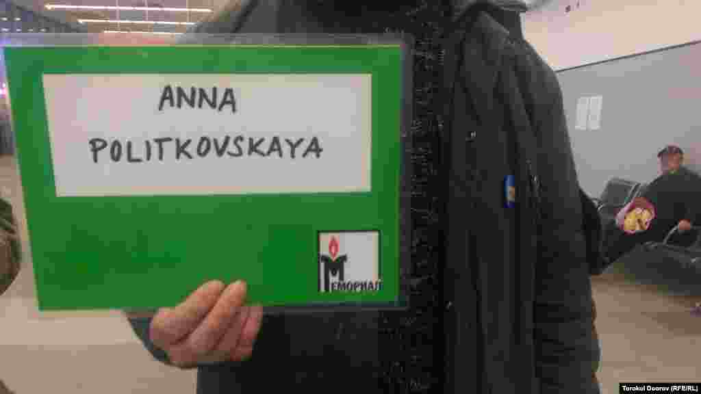Гражданский активист держит в аэропорту табличку с именем убитой российской журналистки Анны Политковской. Журналист освещала нарушения прав человека во время войн в Чечне и была застрелена в лифте своего дома в центре Москвы 7 октября&nbsp;2006 года. Прага, 2 апреля 2015 года.&nbsp;
