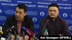 Құрманғазы Мүсір (сол жақта) баспасөз мәслихатында отыр.