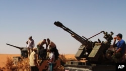 Rebel fighters take control of a military vehicle some 10 kilometers from Ban Walid on September 7.