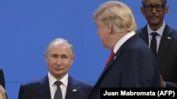 Donald Trump se uită la președintele Rusiei, Vladimir Putin, în timpul unei fotografii de familie la summitul liderilor G20 de la Buenos Aires, noiembrie 2018.