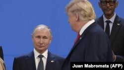 Президент США Дональд Трамп проходит мимо президента России Владимира Путина, когда участники саммита «Группы двадцати» готовились к коллективной фотографии. Аргентина, Буэнос-Айрес, 30 ноября 2018 года