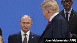 Президент США Дональд Трамп проходить повз президента Росії Володимира Путіна, коли учасники саміту «Групи двадцяти» готувалися до колективної фотографії. Аргентина, Буенос-Айресі, 30 листопада 2018 року