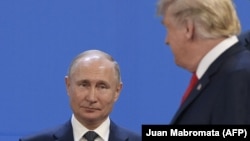 ARGENTINA – US President Donald Trump (R), looks at Russia's President Vladimir Putin as they take place for a family photo, during the G20 Leaders' Summit in Buenos Aires, on November 30, 2018