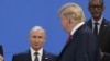 US President Donald Trump (R), looks at Russia's President Vladimir Putin as they take place for a family photo, during the G20 Leaders' Summit in Buenos Aires, on November 30, 2018