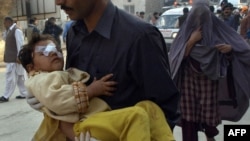 A volunteer carries a child injured in a car bomb blast in Peshawar on November 16.